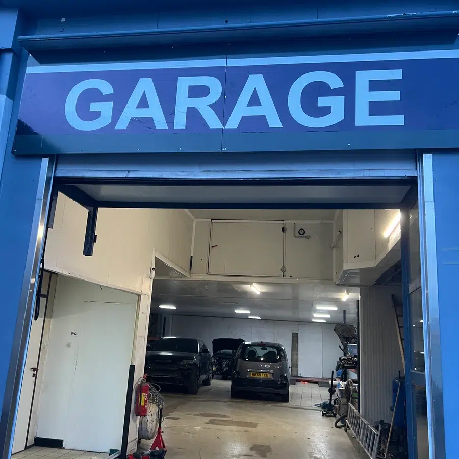 Entrée d'un garage avec voitures à l'intérieur