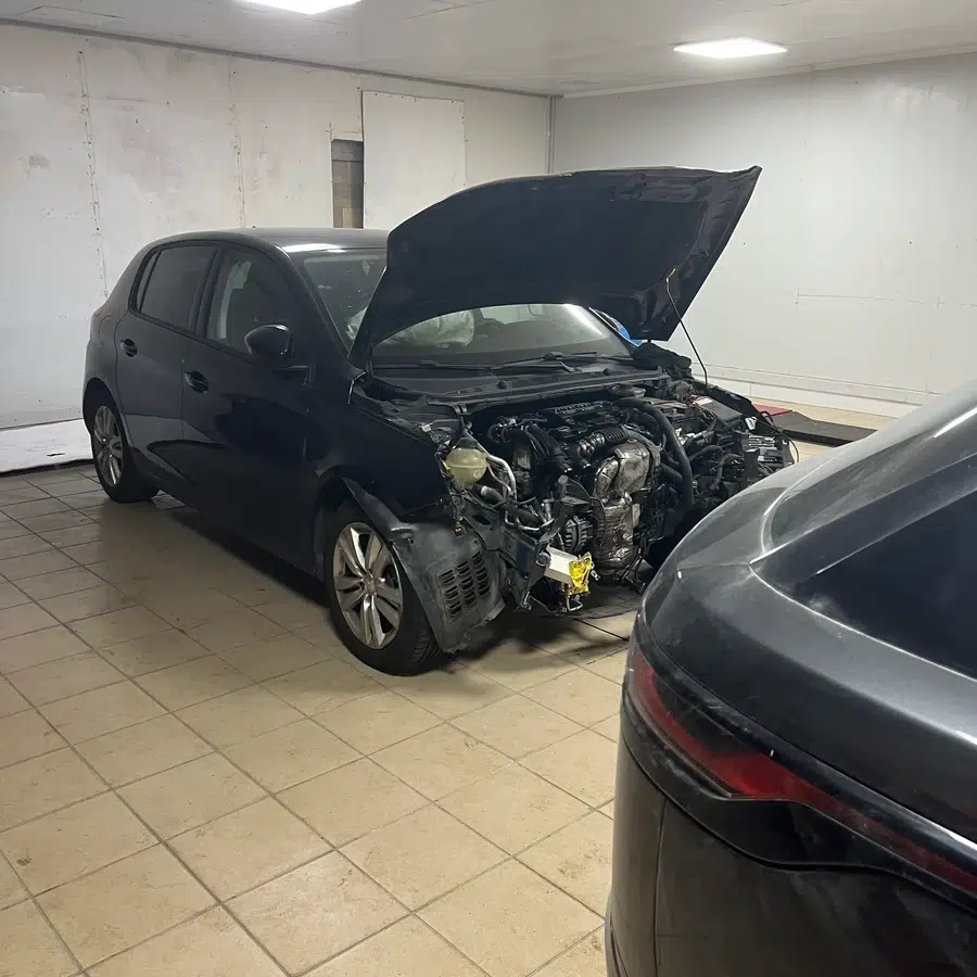 Voiture avec capot ouvert dans un garage