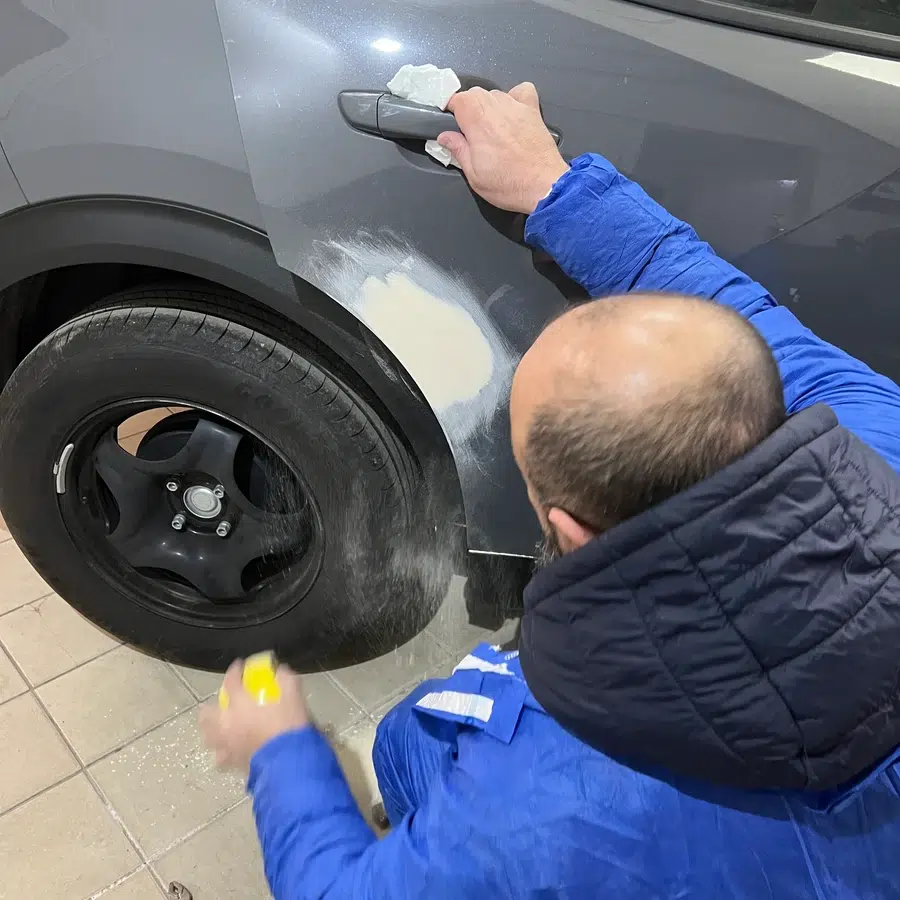 Réparation de carrosserie automobile Homme réparant une carrosserie de voiture